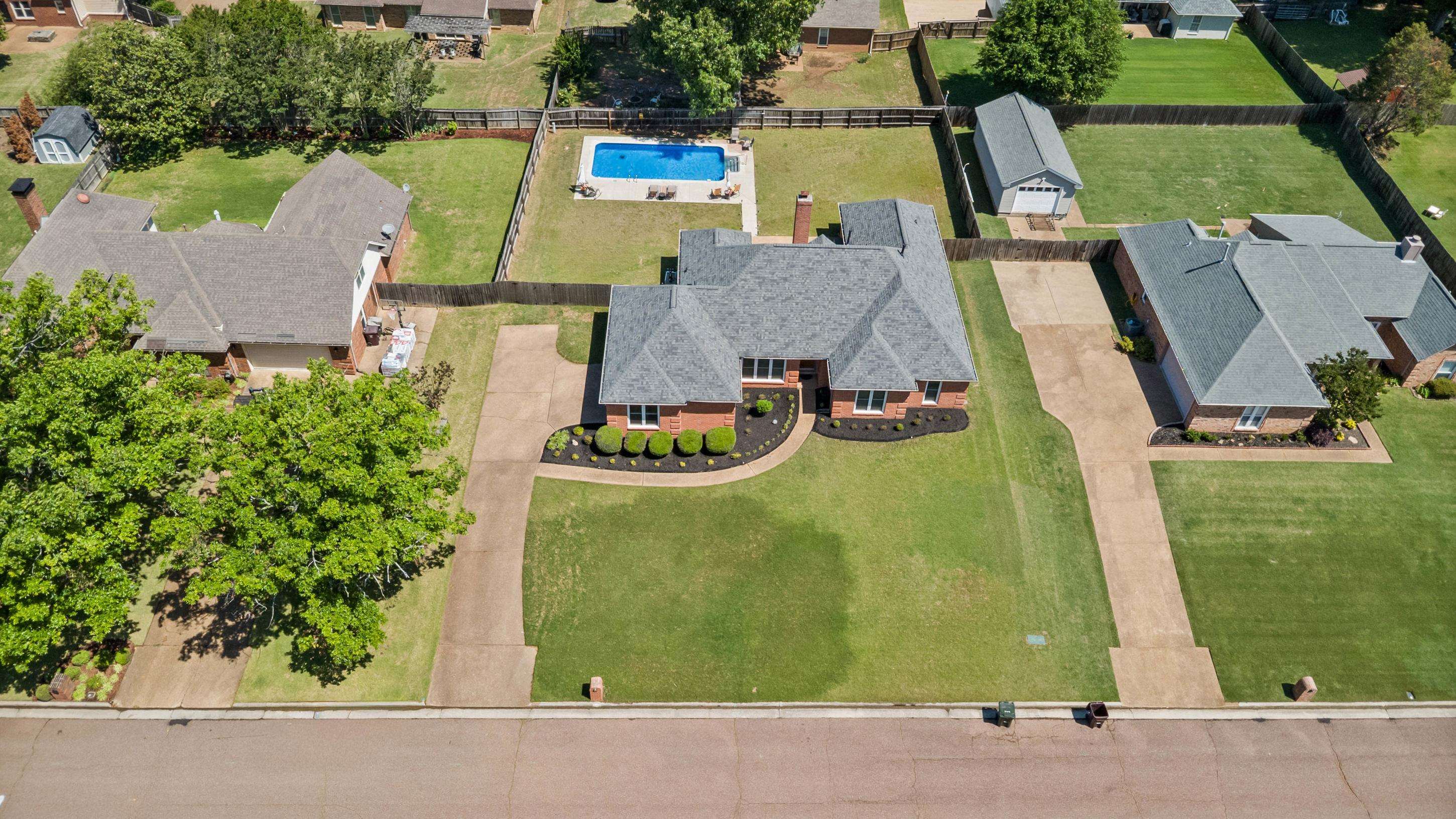 304 Spring Mill Road Collierville, TN 38017 - Photo 29 of 32 Brick-front residence featuring a dark gray shingle roof, established landscaping, and a substantial front lawn