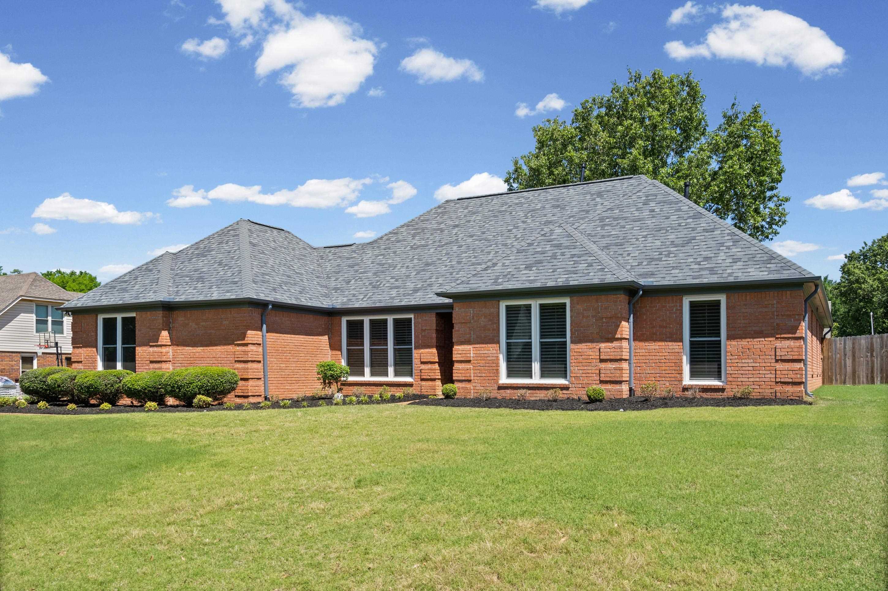 304 Spring Mill Road Collierville, TN 38017 - Photo 4 of 32 Brick exterior with white window trim and a grey shingle roof