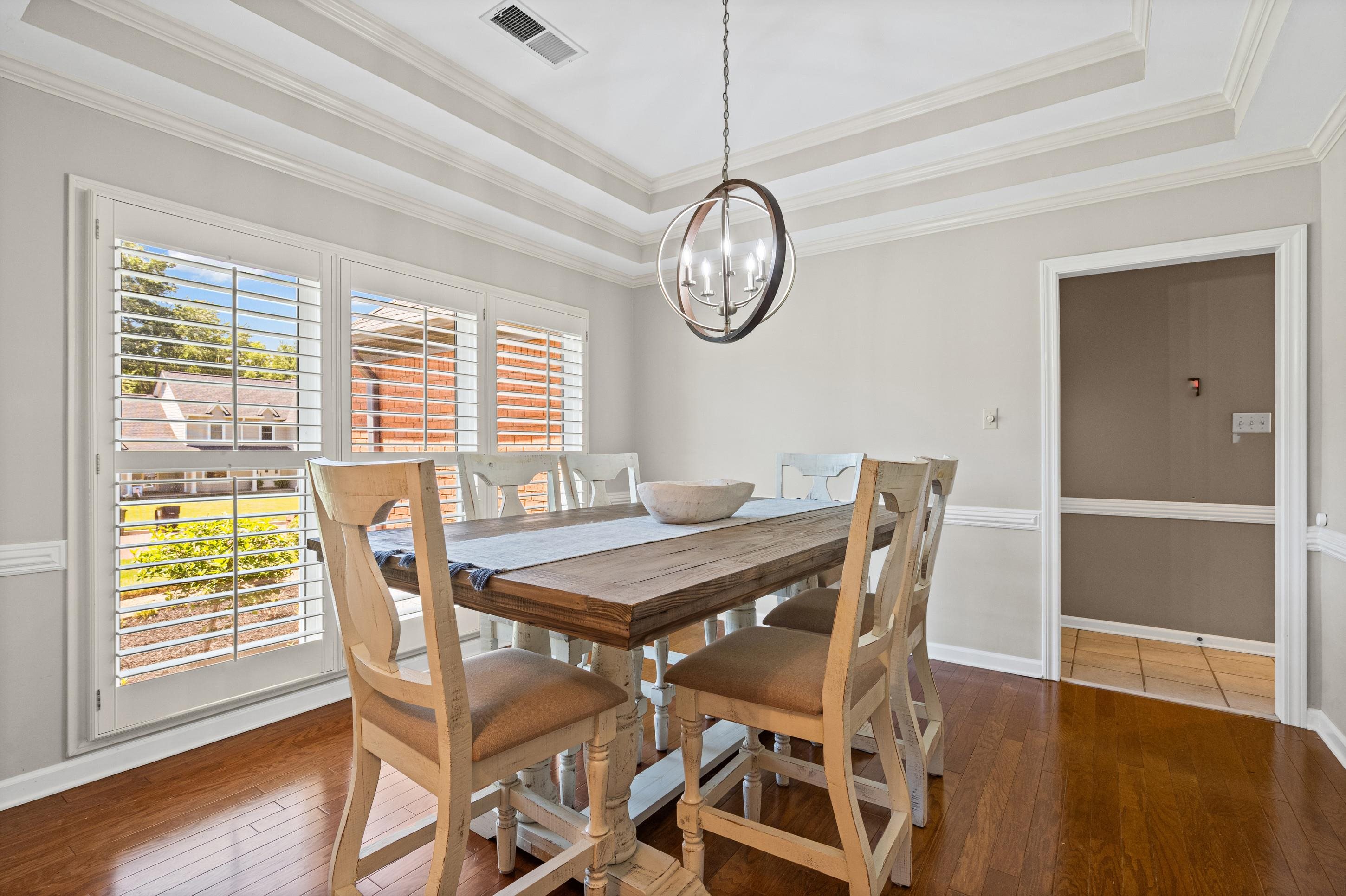 304 Spring Mill Road Collierville, TN 38017 - Photo 6 of 32 Dining space featuring a coffered ceiling, a contemporary circular chandelier, wood-finish flooring, and window shutters