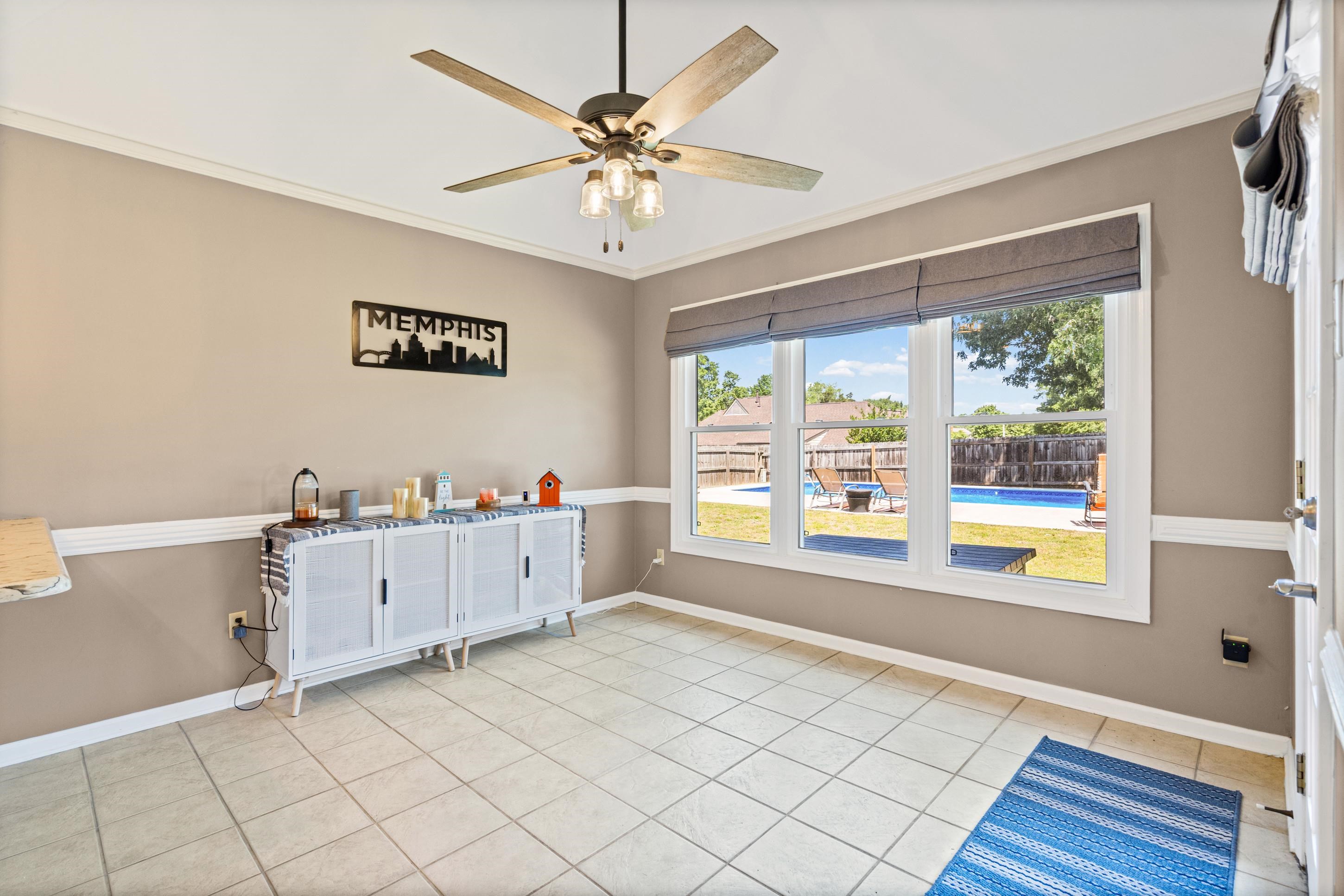 304 Spring Mill Road Collierville, TN 38017 - Photo 10 of 32 Bright room featuring a three-panel window overlooking a backyard with a swimming pool