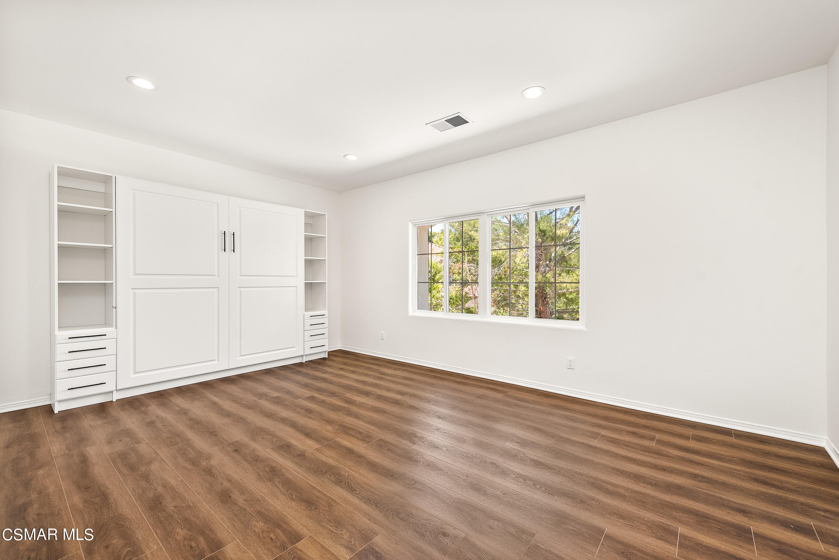 3877 Marks Road Agoura Hills, CA 91301 - Photo 34 of 53 an empty room with wooden floor cabinet and windows