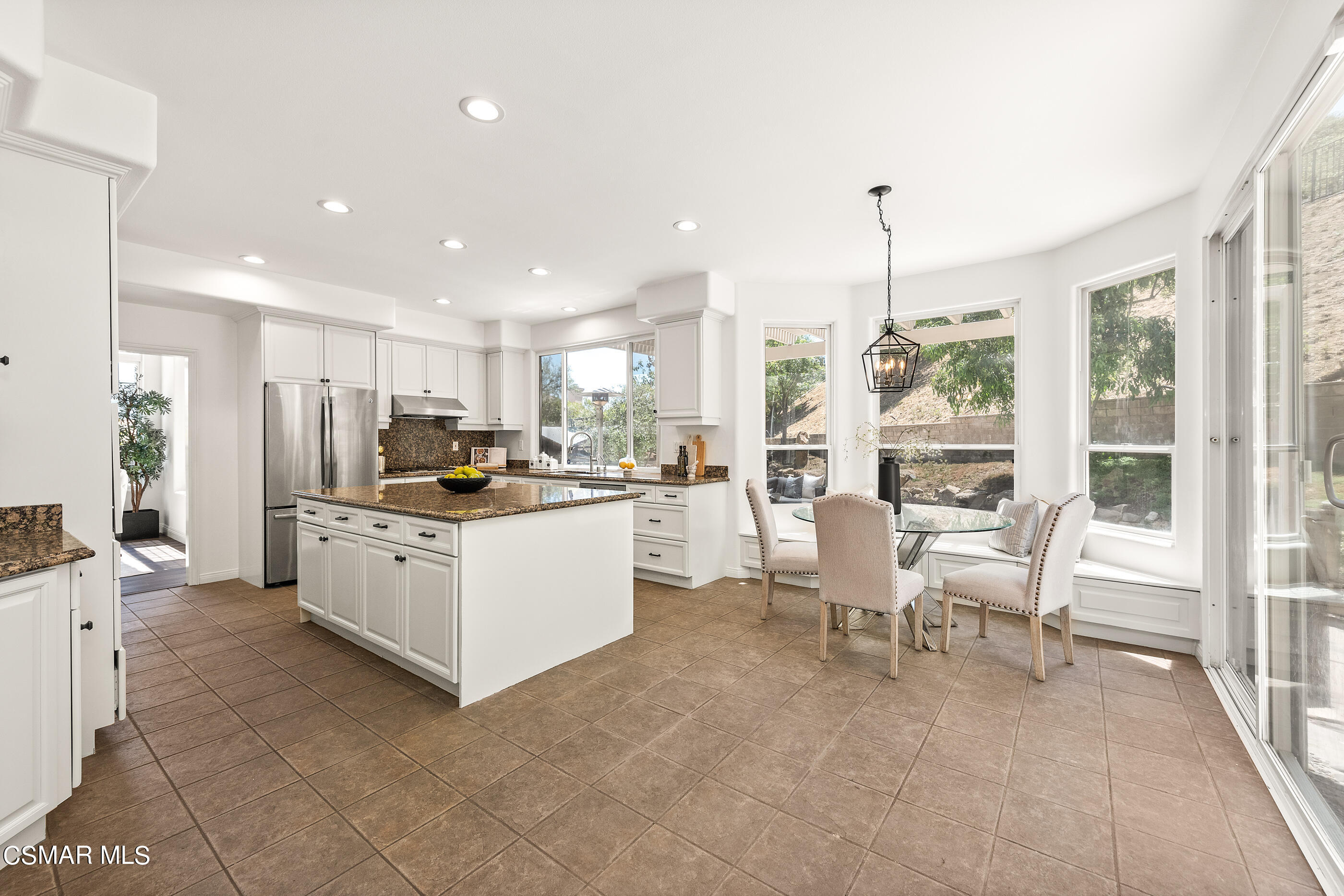 3877 Marks Road Agoura Hills, CA 91301 - Photo 9 of 53 a kitchen with stainless steel appliances kitchen island granite countertop a stove a sink a dining table and chairs