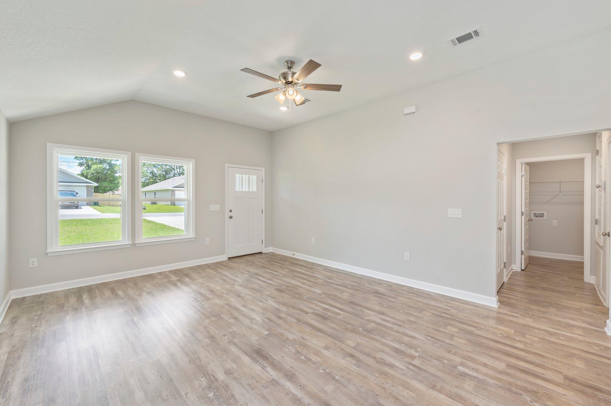 3158 Chestnut Street Crestview, FL 32539 - Photo 5 of 26 a view of an empty room with wooden floor and a window