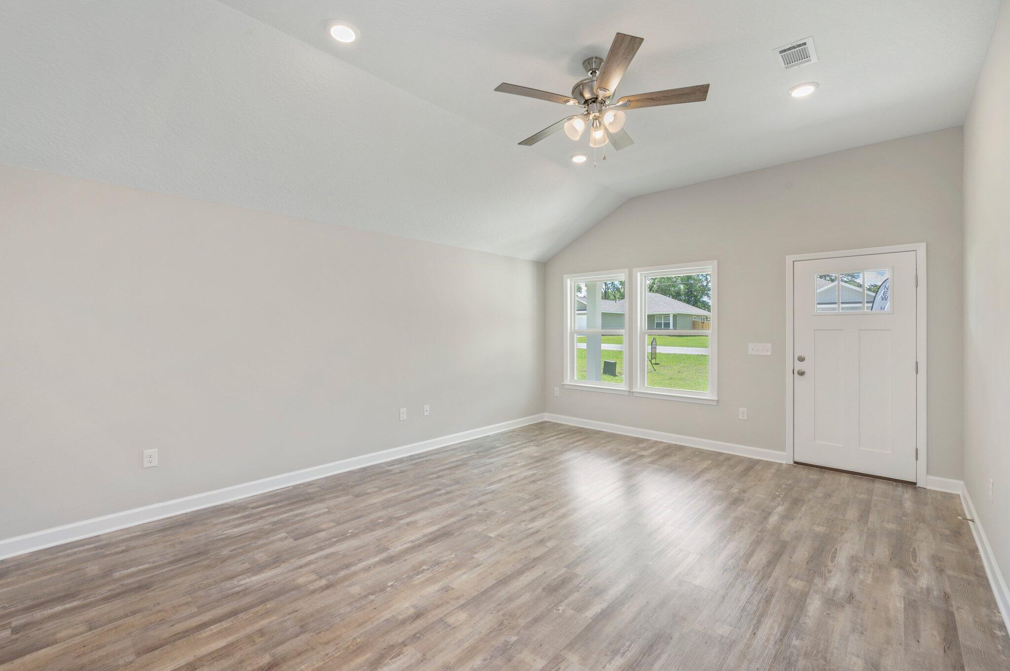 3158 Chestnut Street Crestview, FL 32539 - Photo 6 of 26 an empty room with wooden floor fan and windows