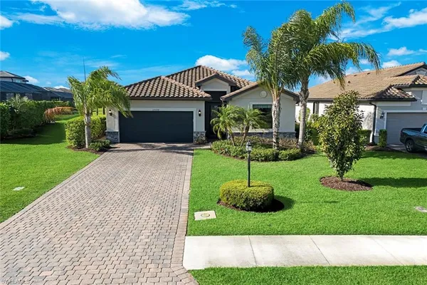 a view of a house with a yard and palm trees