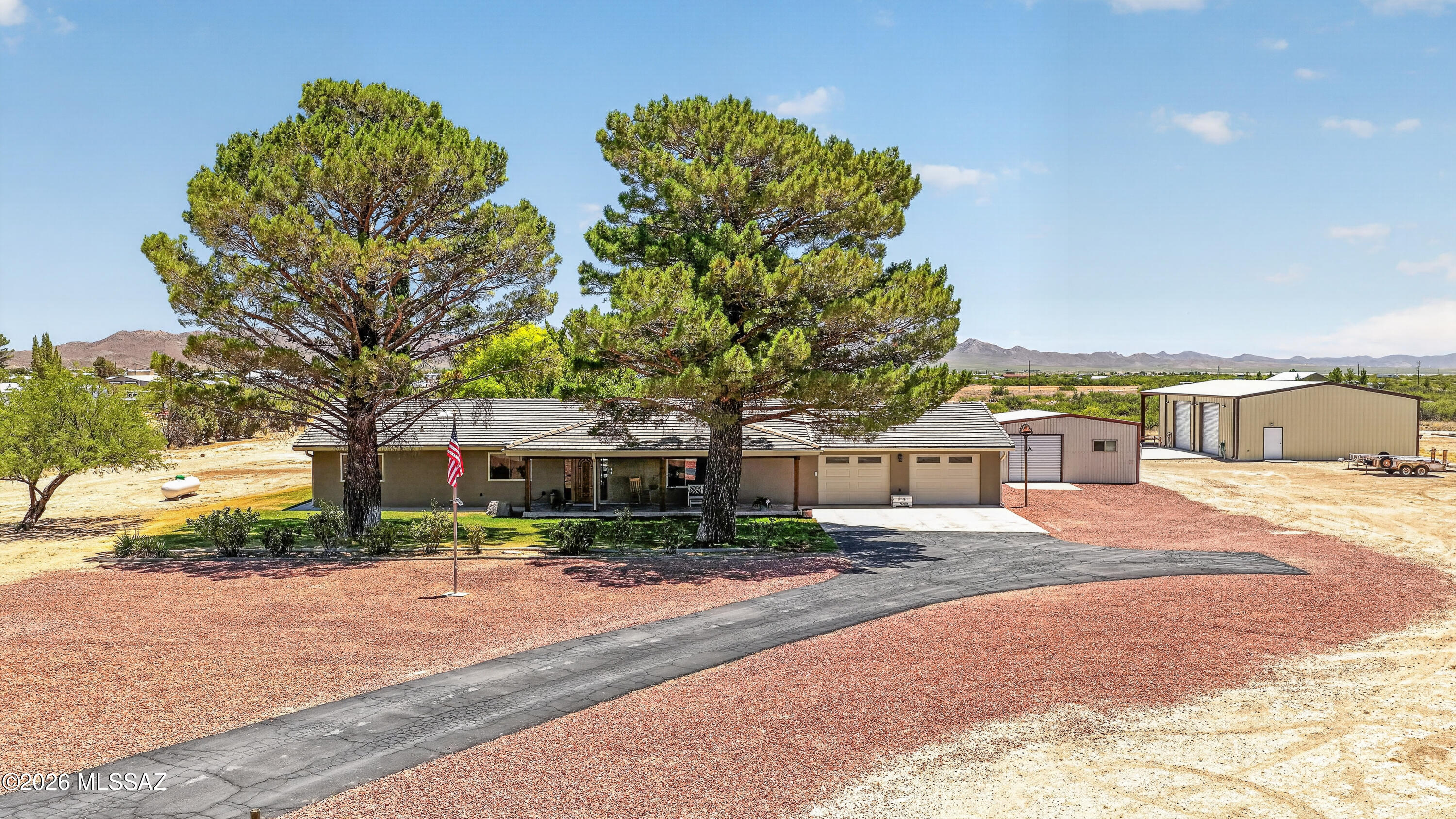 194 Taylor Road Willcox, AZ 85643 - Photo 1 of 54 Front of House, asphalt driveway, 2nd Driveway entrance is dirt which wraps around house to Shop, gravel, large trees, Grass - 2 shops