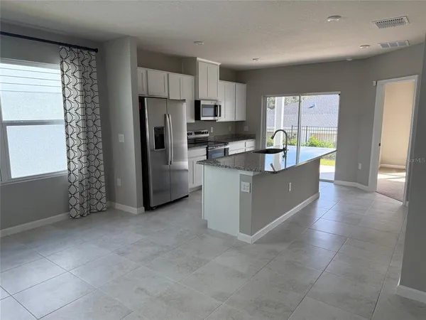 a large kitchen with stainless steel appliances granite countertop a refrigerator and a stove top oven