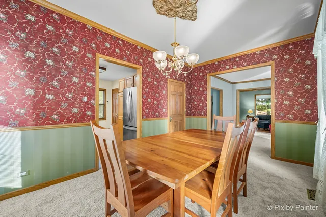 a view of a dining room with furniture and a chandelier
