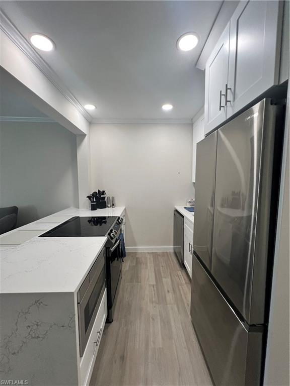 473 12th Avenue South, Unit B6 Naples, FL 34102 - Photo 1 of 10 a kitchen with granite countertop a refrigerator a sink and wooden floor