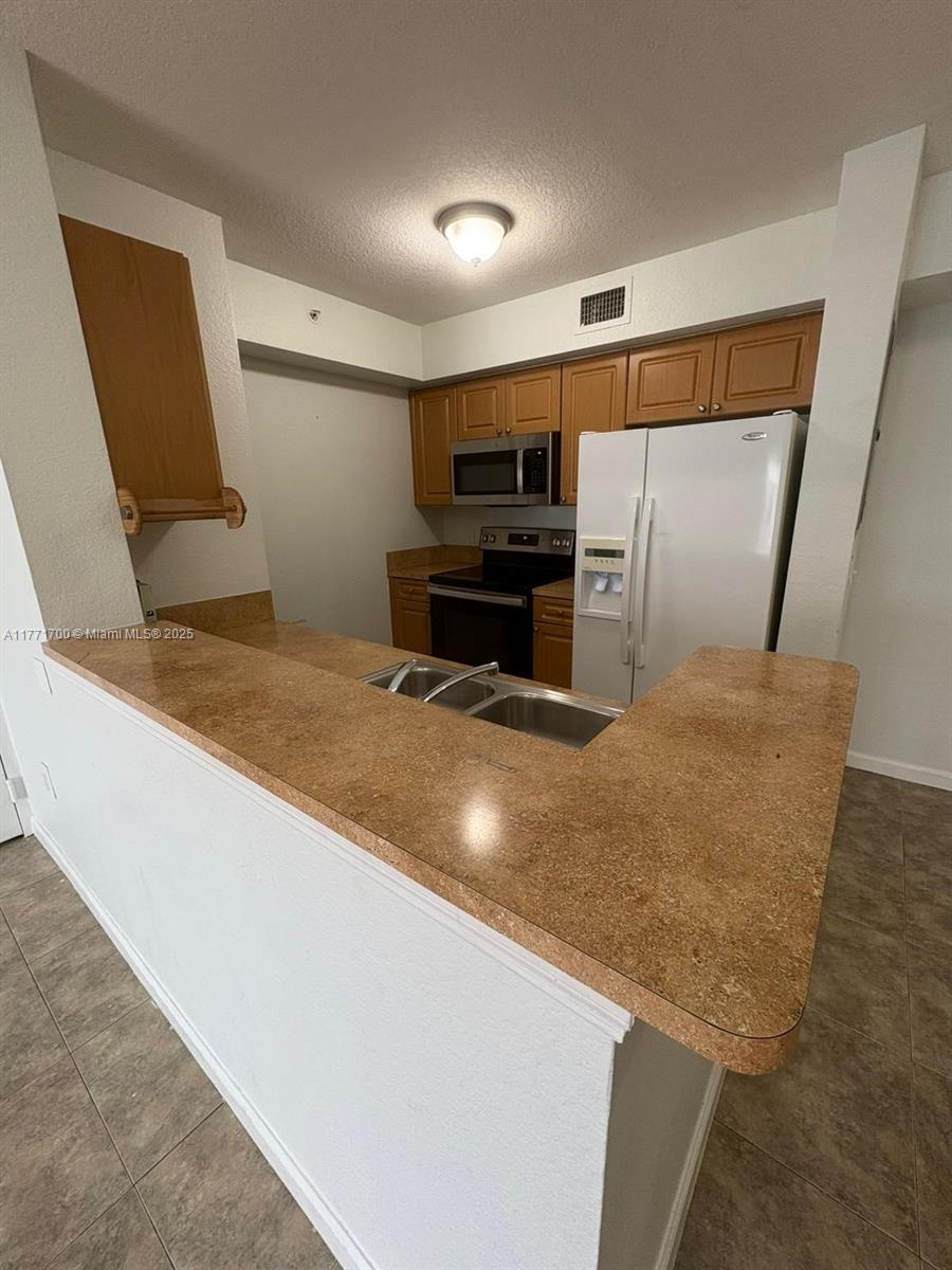 15422 Southwest 284th Street, Unit 7302 Homestead, FL 33033 - Photo 11 of 44 a kitchen with stainless steel appliances granite countertop a sink and a refrigerator