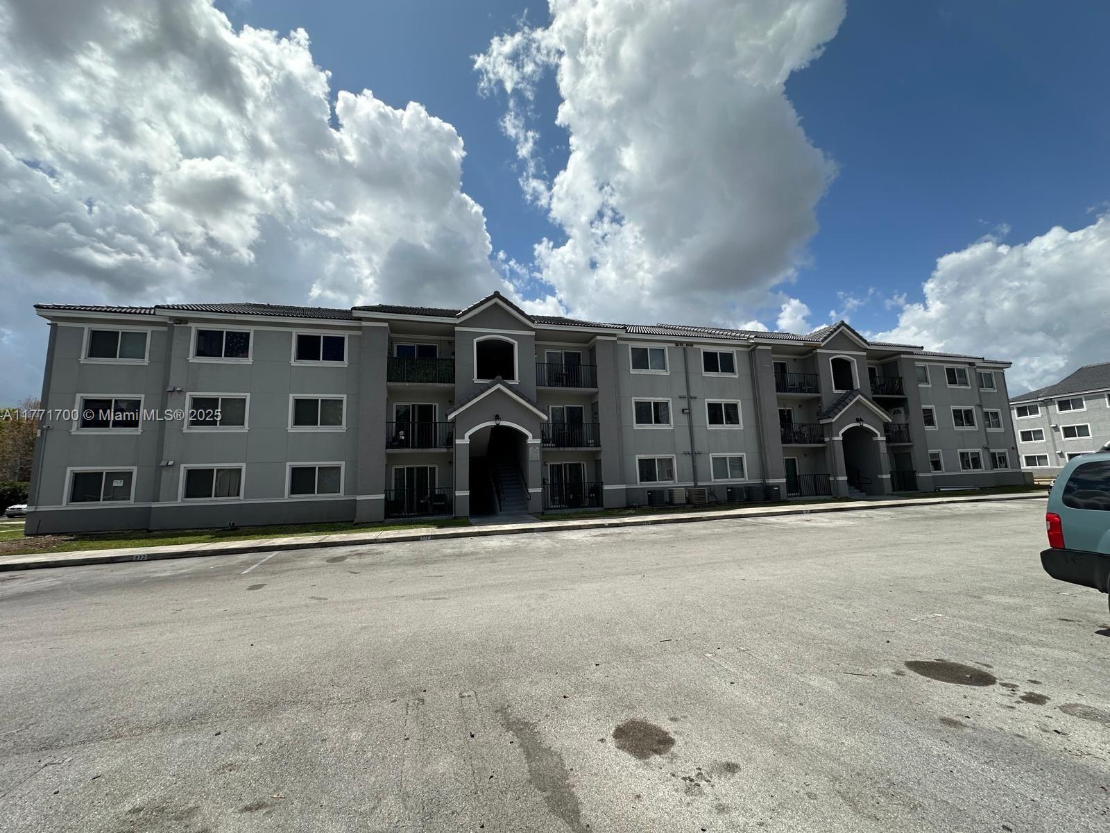 15422 Southwest 284th Street, Unit 7302 Homestead, FL 33033 - Photo 33 of 44 a front view of a building with a lot of windows