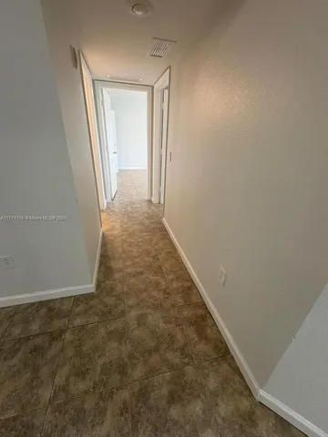 a kitchen that has a sink a refrigerator and a microwave