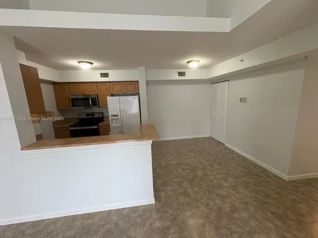 a kitchen with stainless steel appliances granite countertop a sink and a refrigerator