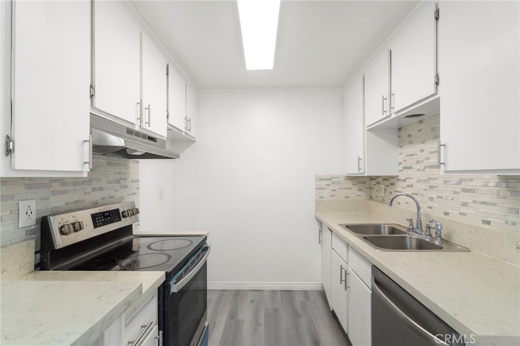 5535 Ackerfield Avenue, Unit 8 Long Beach, CA 90805 - Photo 11 of 31 a kitchen with stainless steel appliances granite countertop a sink a stove and a refrigerator