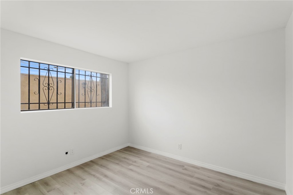 5535 Ackerfield Avenue, Unit 8 Long Beach, CA 90805 - Photo 15 of 31 a view of an empty room with wooden floor and a window