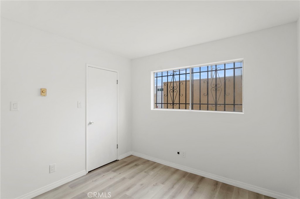 5535 Ackerfield Avenue, Unit 8 Long Beach, CA 90805 - Photo 16 of 31 a view of an empty room with wooden floor and a window