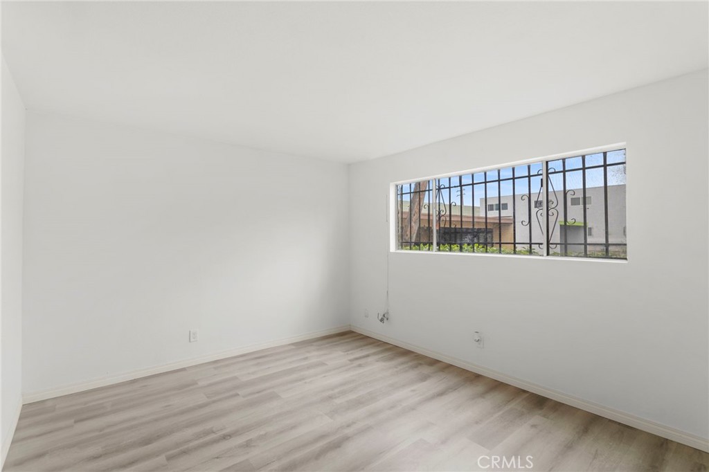 5535 Ackerfield Avenue, Unit 8 Long Beach, CA 90805 - Photo 18 of 31 a view of an empty room with wooden floor and a window