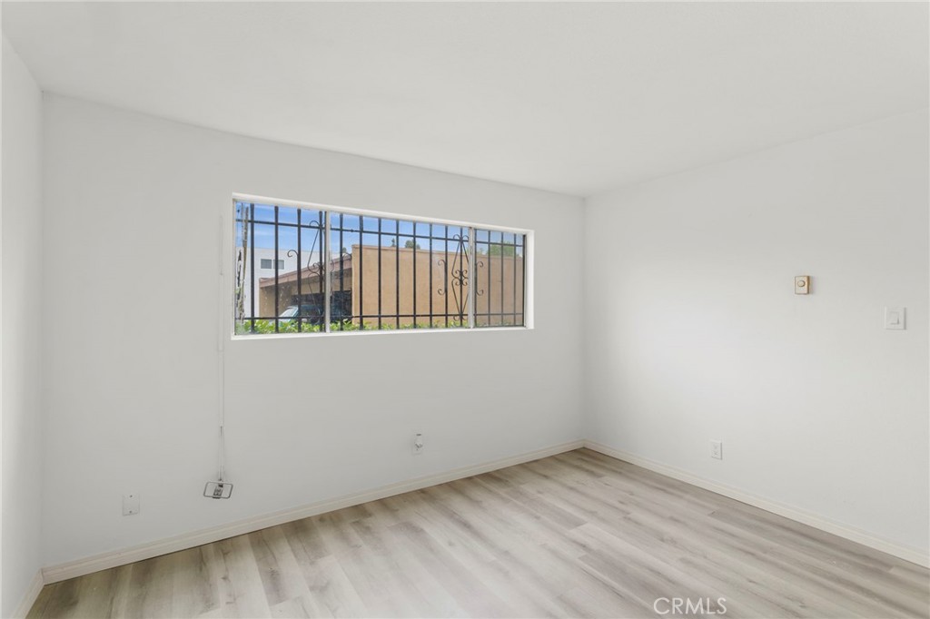 5535 Ackerfield Avenue, Unit 8 Long Beach, CA 90805 - Photo 21 of 31 a view of an empty room with wooden floor and a window