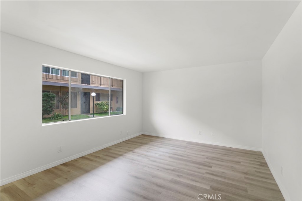 5535 Ackerfield Avenue, Unit 8 Long Beach, CA 90805 - Photo 4 of 31 a view of an empty room with wooden floor and a window