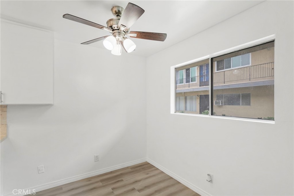 5535 Ackerfield Avenue, Unit 8 Long Beach, CA 90805 - Photo 10 of 31 a view of an empty room with wooden floor and a ceiling fan