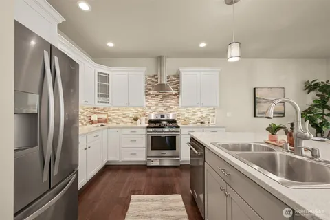 a kitchen with a sink cabinets stainless steel appliances and a window