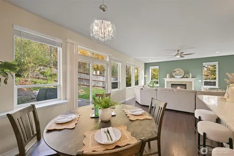 a dining room with furniture a large window and wooden floor