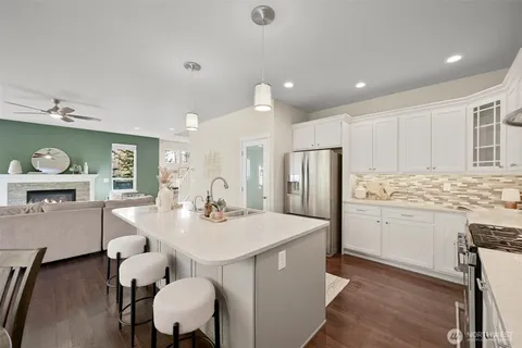 a kitchen with a dining table chairs refrigerator and cabinets