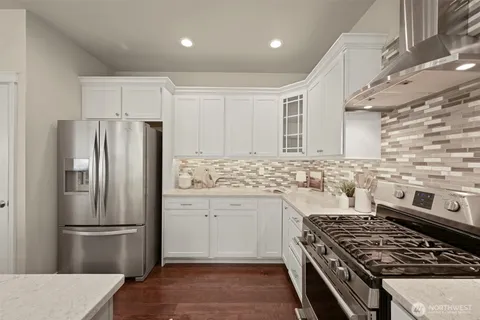a kitchen with stainless steel appliances granite countertop a stove and a refrigerator