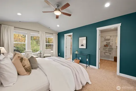 a bedroom with a bed ceiling fan and a window