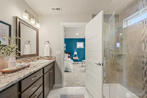 a en suite bathroom with a granite countertop sink mirror and shower