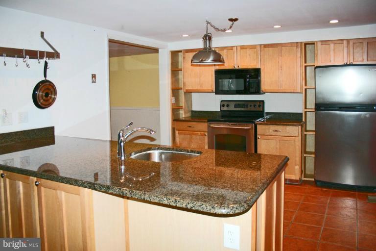 4835 Maple Grove Road Hampstead, MD 21074 - Photo 21 of 27 a kitchen with stainless steel appliances granite countertop a sink a microwave and a refrigerator
