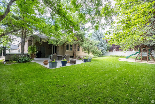 288 525 South Providence, UT 84332 - Photo 62 of 71 Spacious backyard featuring a manicured lawn, established trees, and a hardscaped patio with outdoor seating