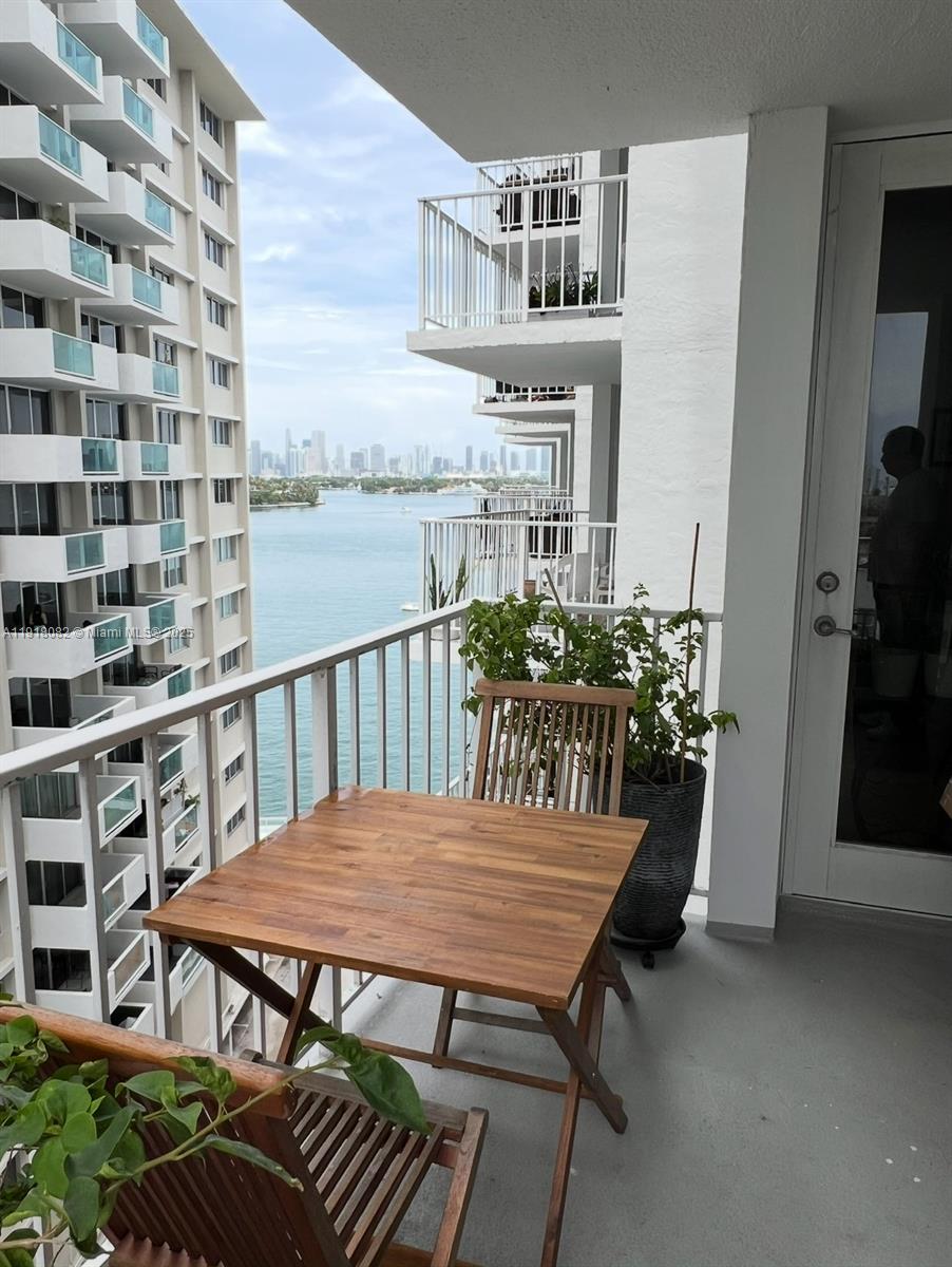 1228 West Avenue, Unit 911 Miami Beach, FL 33139 - Photo 12 of 24 a view of a balcony dining table and chairs with potted plants