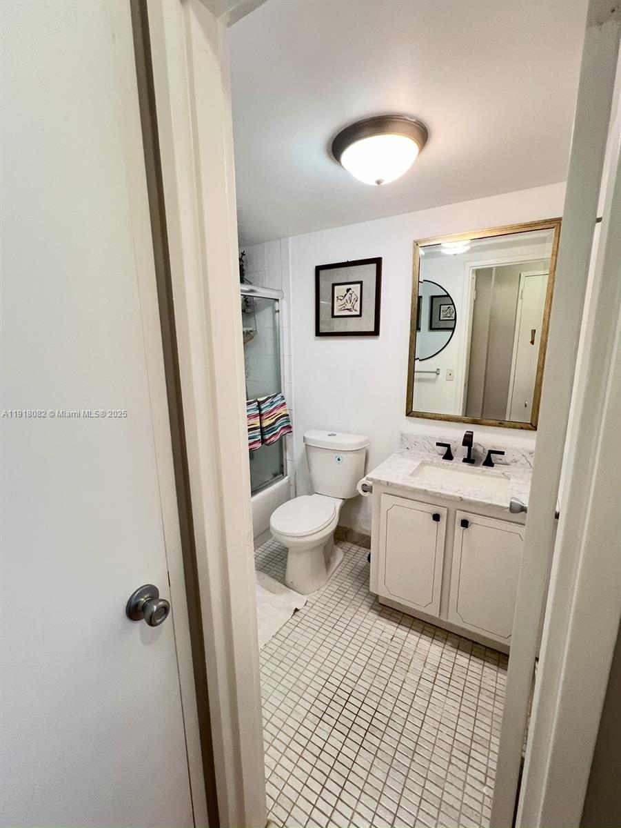 1228 West Avenue, Unit 911 Miami Beach, FL 33139 - Photo 20 of 24 a bathroom with a sink a toilet a shower a mirror and vanity