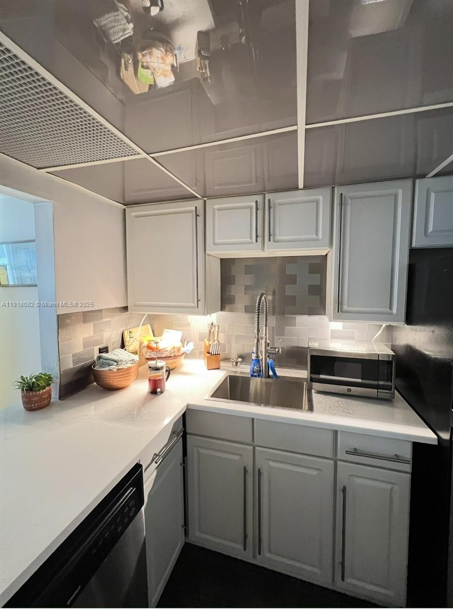 1228 West Avenue, Unit 911 Miami Beach, FL 33139 - Photo 4 of 24 a kitchen with sink a stove and cabinets