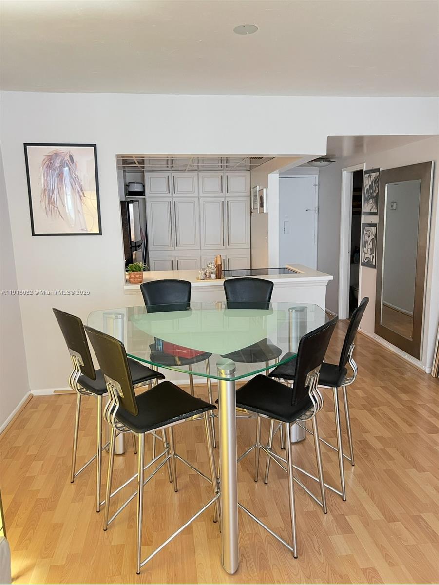 1228 West Avenue, Unit 911 Miami Beach, FL 33139 - Photo 8 of 24 a view of a dining room with furniture and wooden floor
