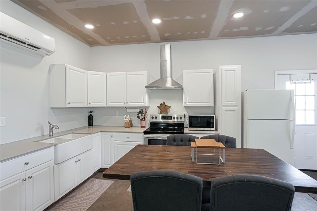 475 Massey Road Gunter, TX 75058 - Photo 33 of 34 White cabinetry, stainless steel range hood, farmhouse-style sink, white refrigerator, and recessed lighting