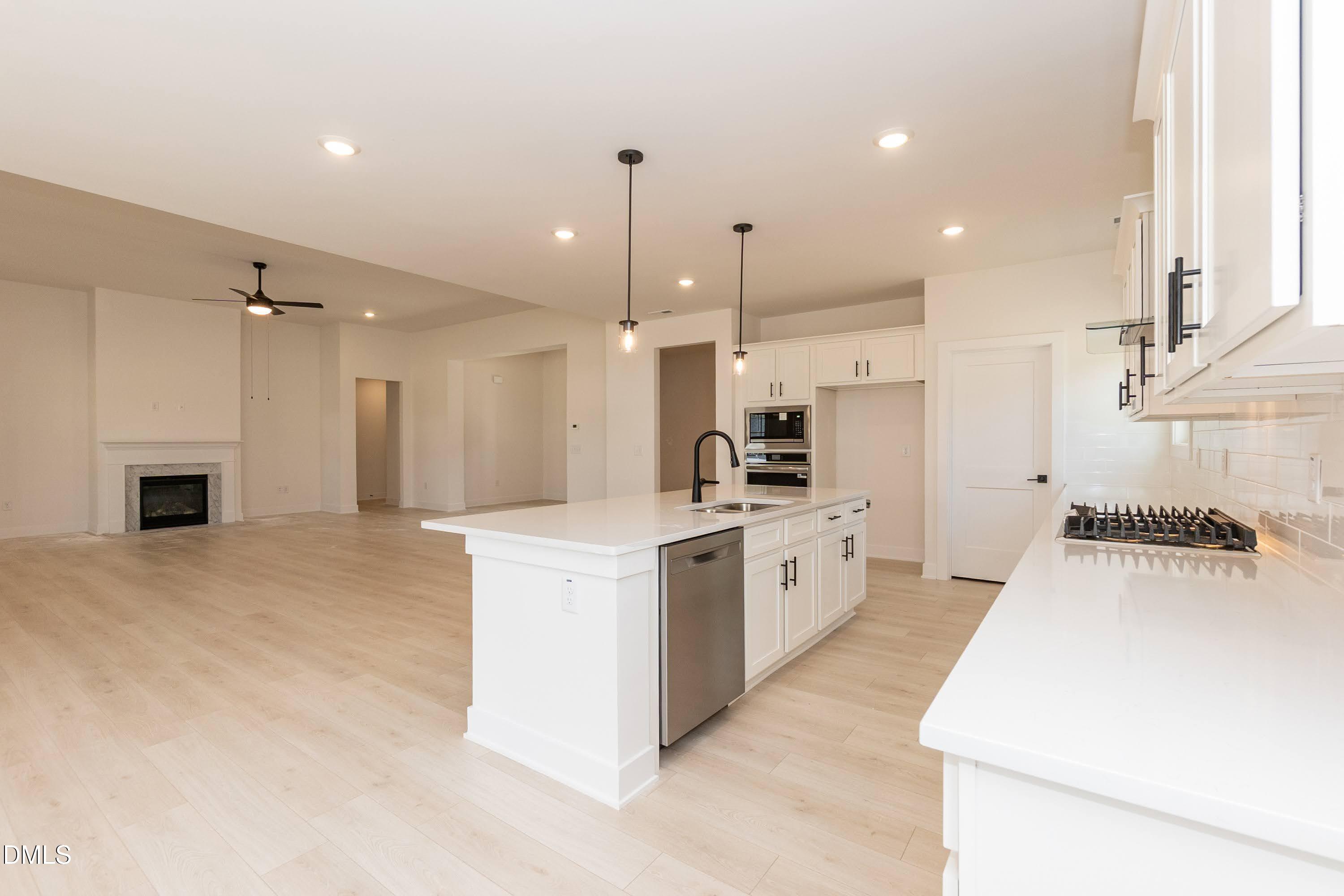 180 Galway Road Lillington, NC 27546 - Photo 14 of 41 a large kitchen with stainless steel appliances kitchen island a stove a sink dishwasher a refrigerator and white cabinets with wooden floor