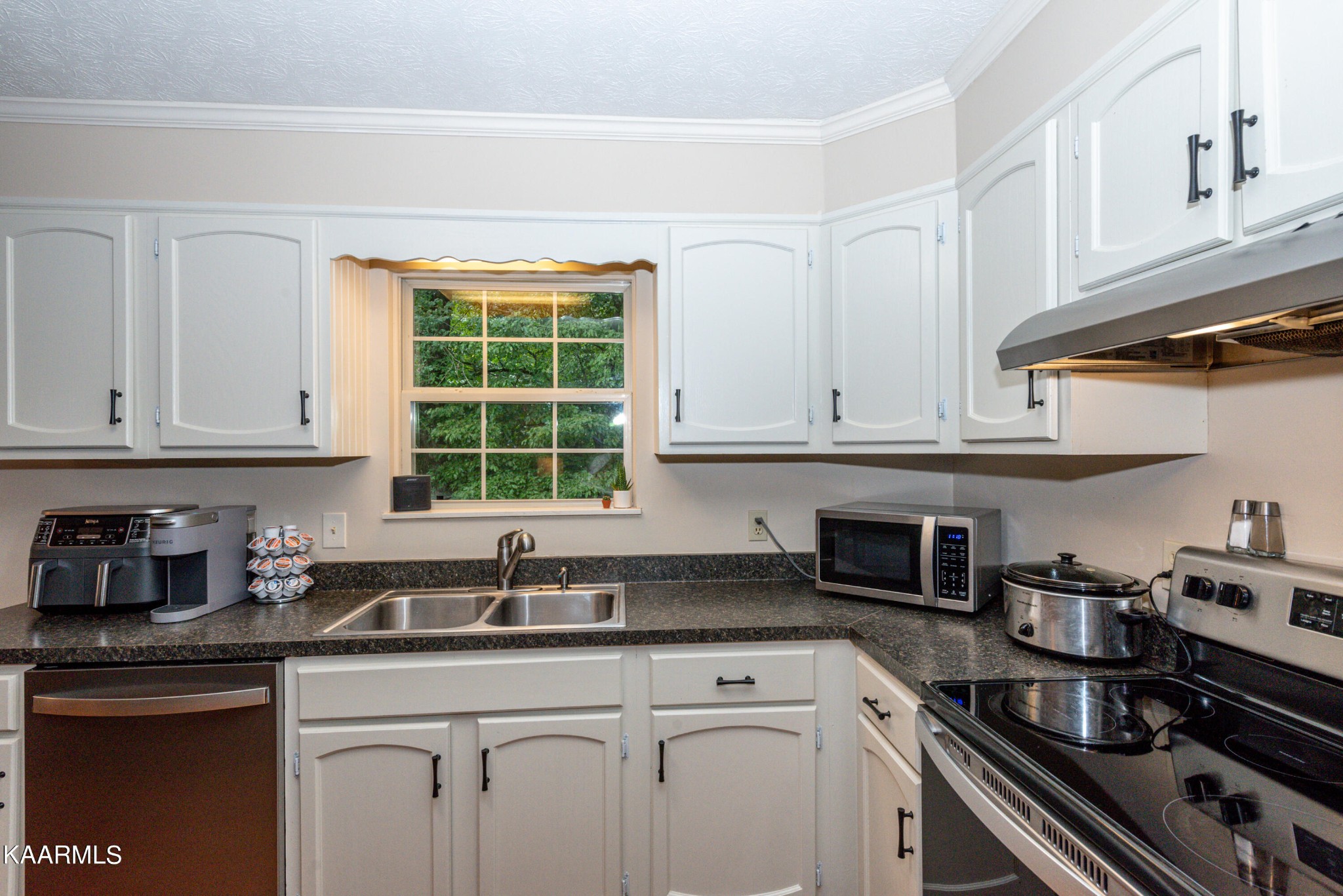 125 Lakeview Estates Road Vonore, TN 37885 - Photo 15 of 46 a kitchen with stainless steel appliances granite countertop white cabinets and a stove top oven