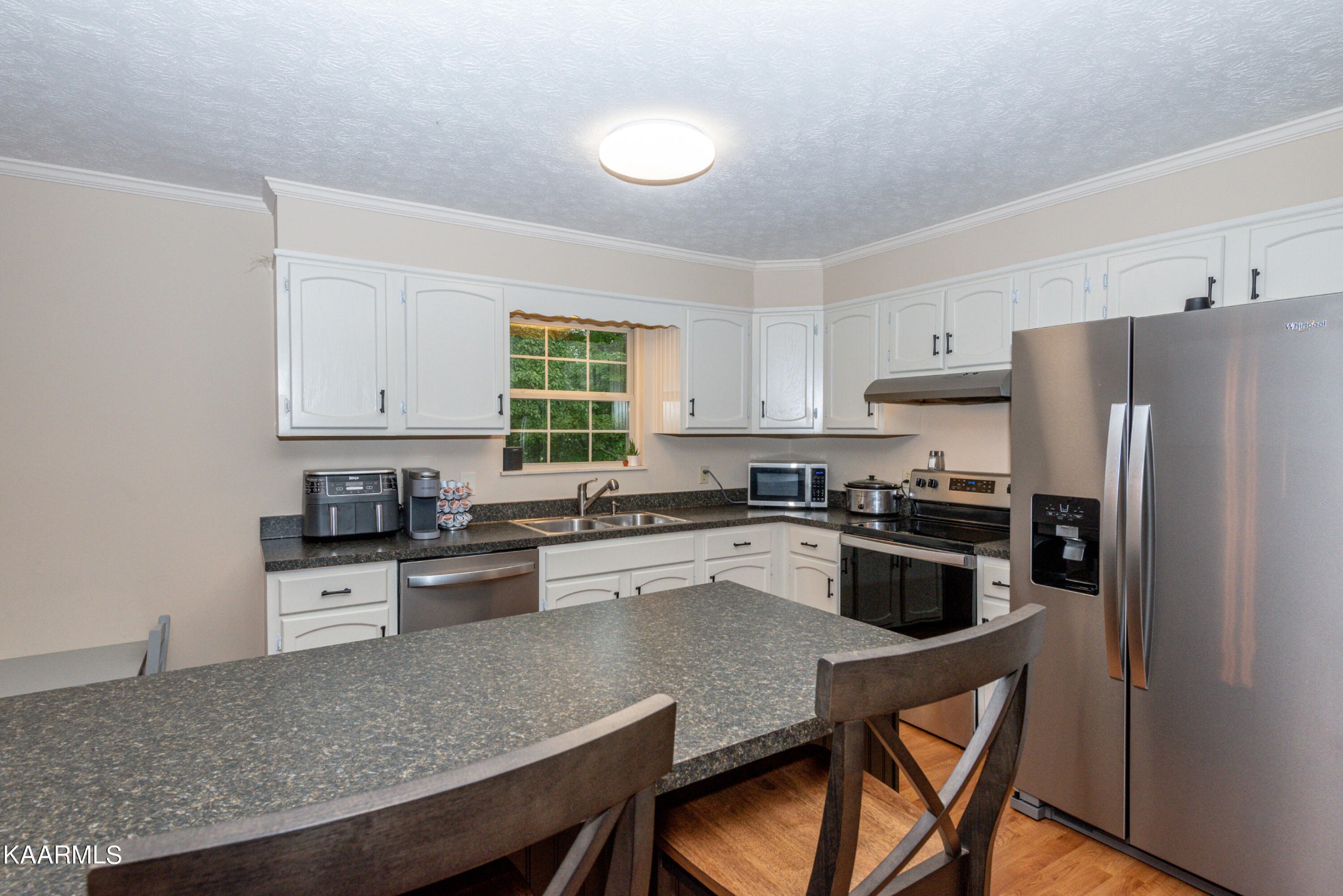 125 Lakeview Estates Road Vonore, TN 37885 - Photo 17 of 46 a kitchen with granite countertop a stove a sink dishwasher a refrigerator and cabinets with wooden floor