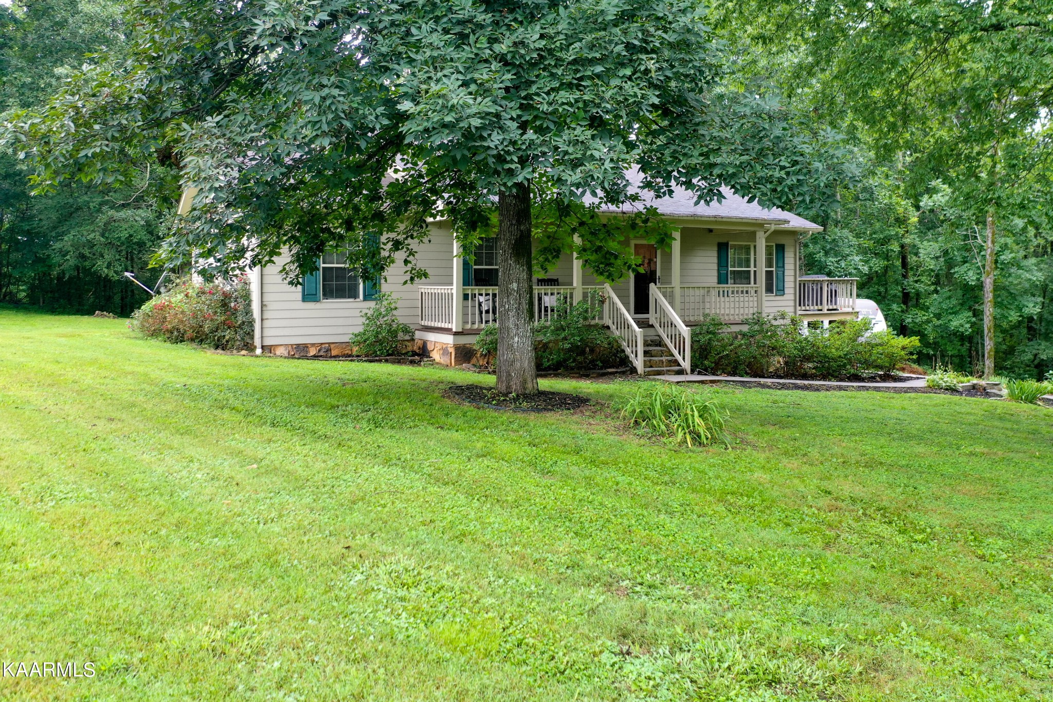 125 Lakeview Estates Road Vonore, TN 37885 - Photo 5 of 46 a front view of a house with a yard porch and a tree