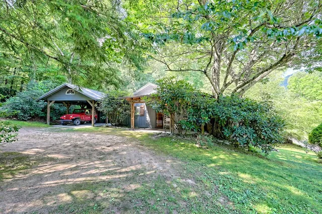 a view of a house with a yard and tree