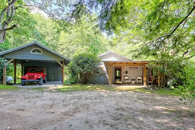 a view of a house with a yard and large trees