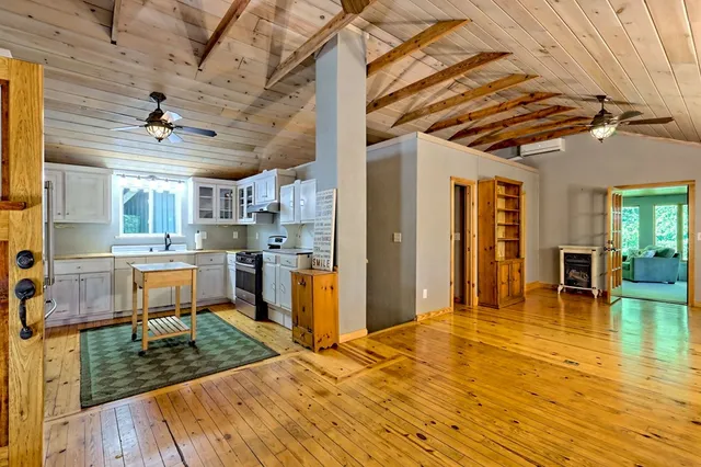 a kitchen with kitchen island granite countertop a stove refrigerator and cabinets