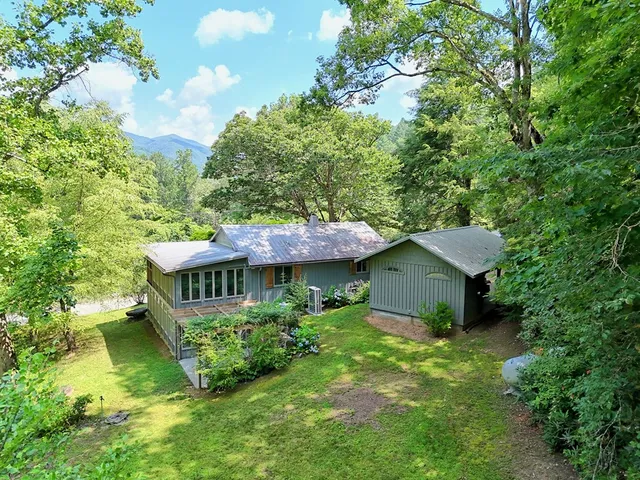 a view of a house with a yard and sitting area