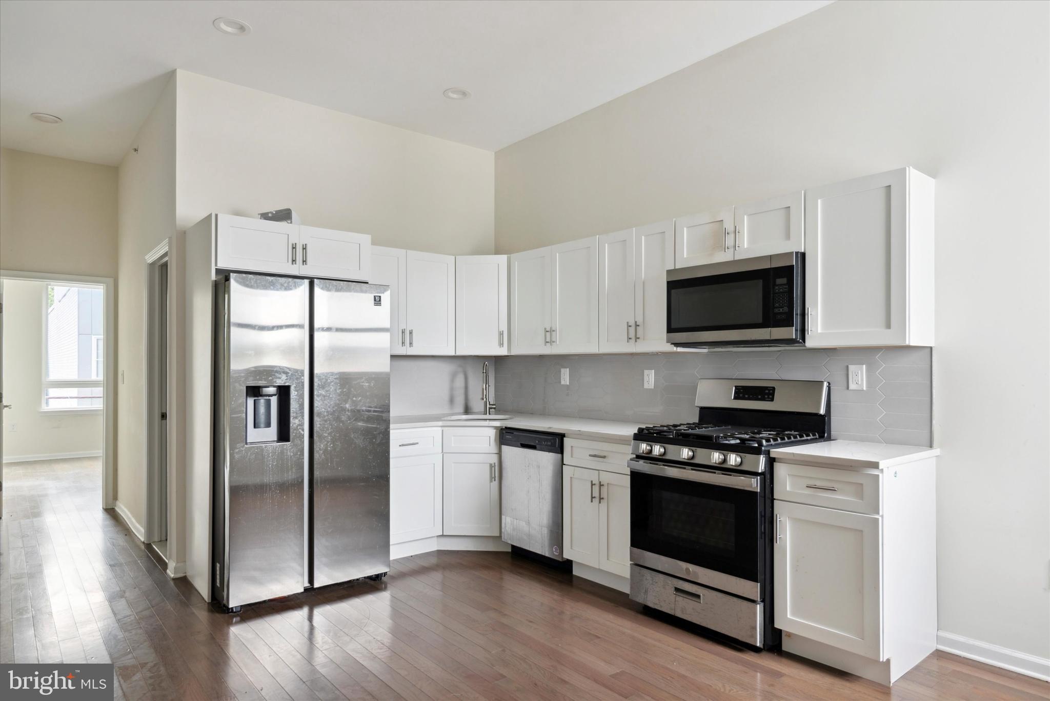 a kitchen with stainless steel appliances a refrigerator a stove top oven and sink