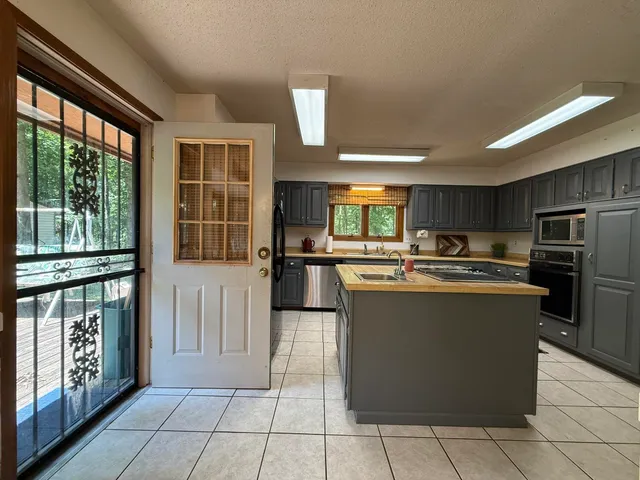 a kitchen with stainless steel appliances granite countertop a refrigerator and a stove