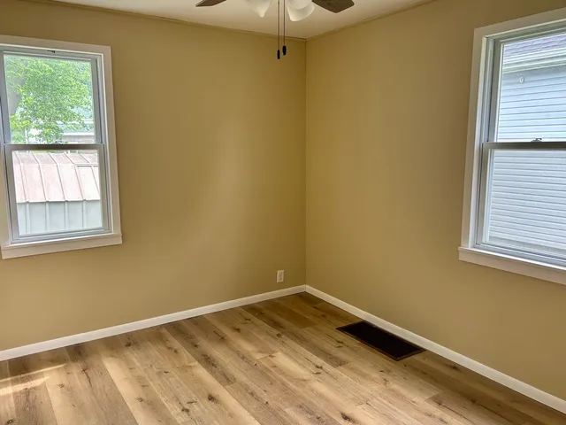 a view of a room with wooden floor and fan