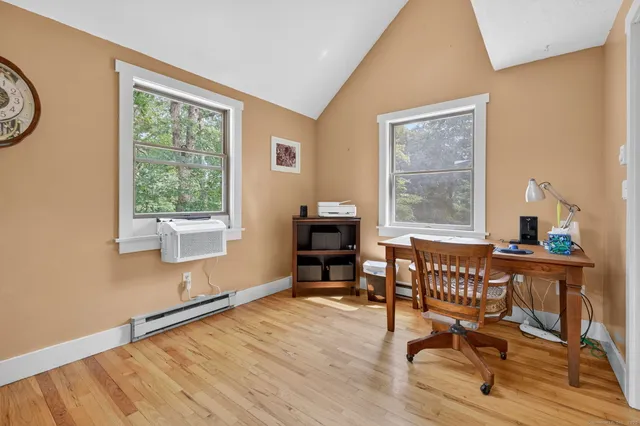 a view of a workspace with furniture and a window