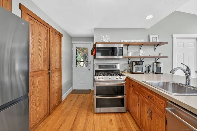 a kitchen with stainless steel appliances a stove a sink and a refrigerator